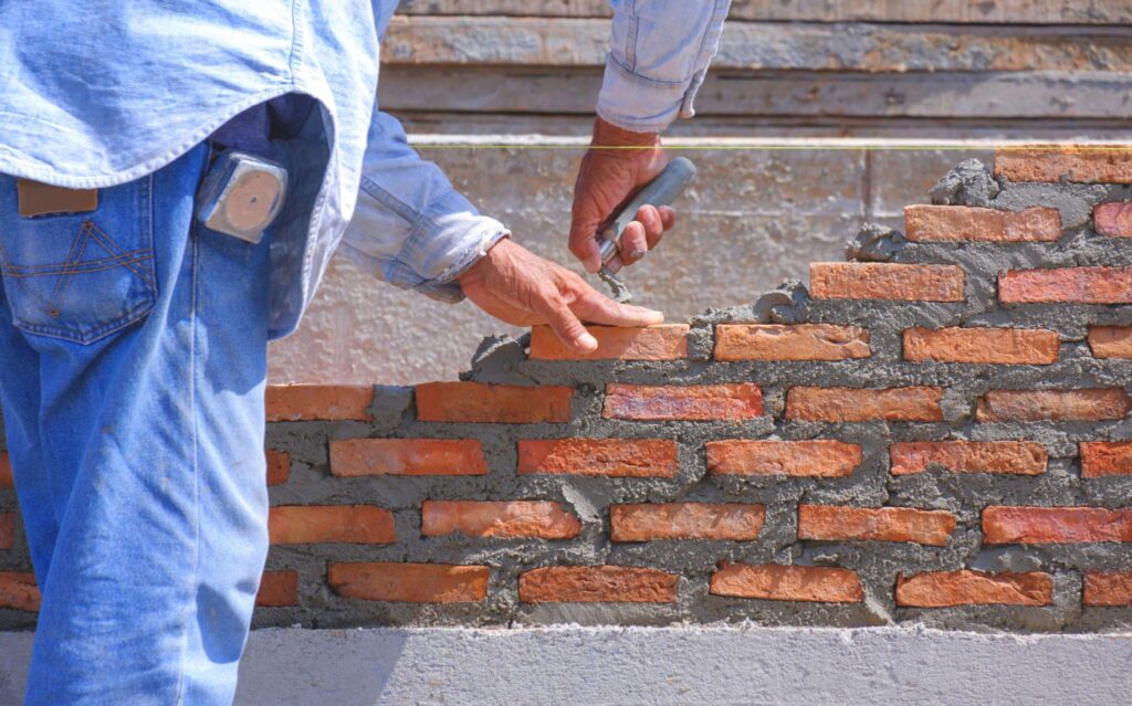 Picture of masonry worker laying bricks
